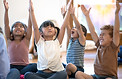Little children and their teacher practicing yoga
