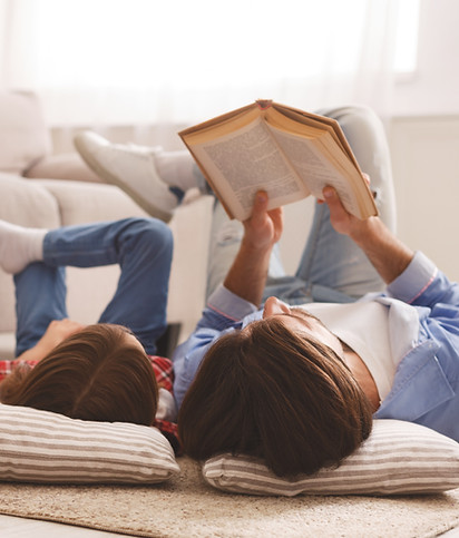 mom and child laying down reading on the floor 