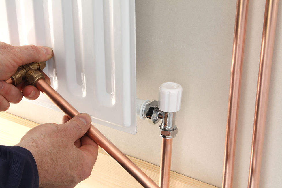 Plumber repairing a central heating radiator