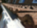 Photo showing some grey stone roof tiles, which have been lifted up slightly so that new w