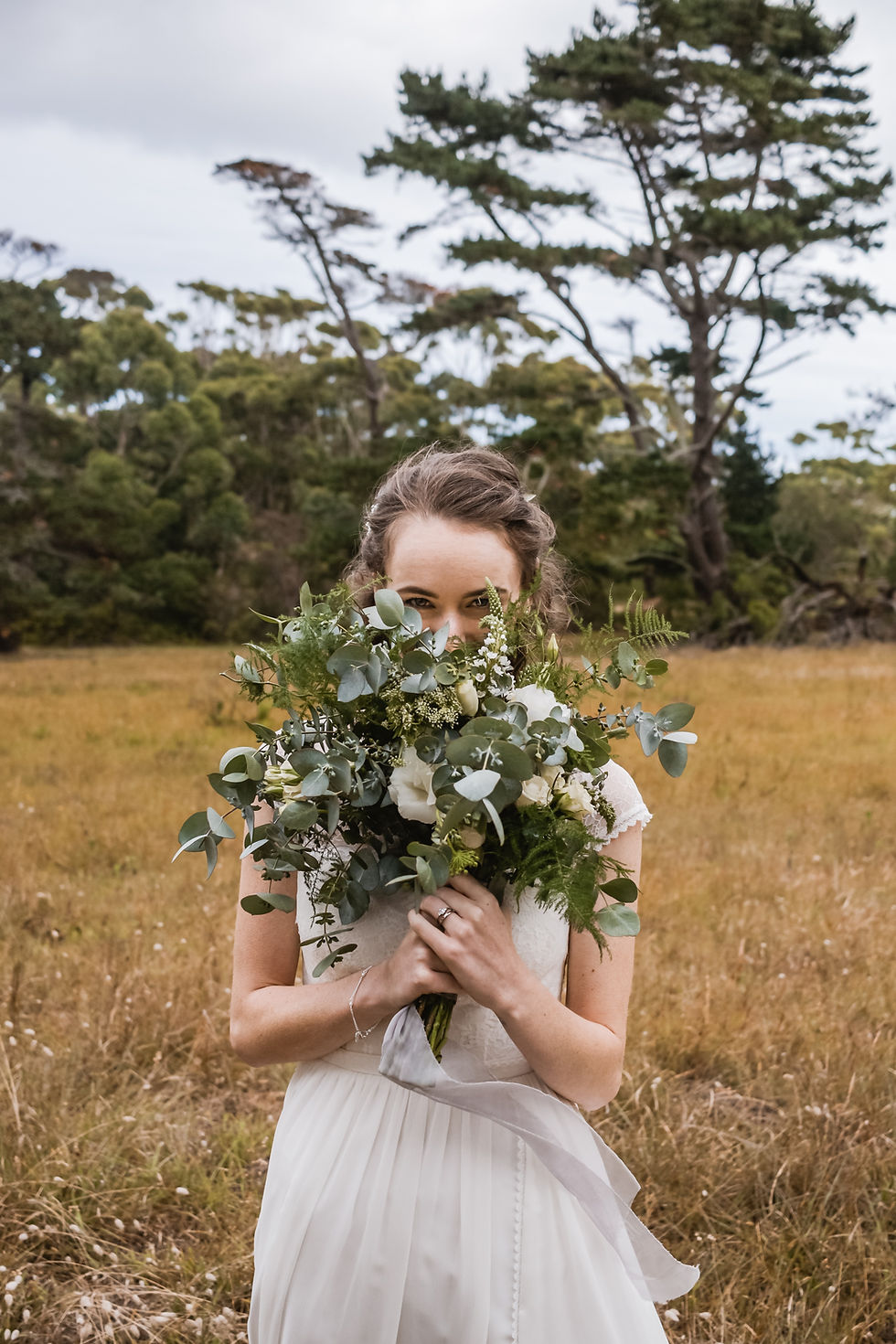Bride in nature holding bouquet
