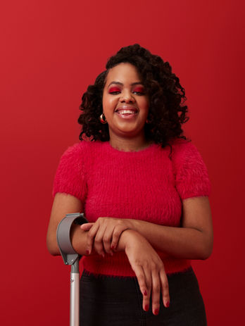 Woman in a red shirt with red background and full smiles and happy. Client Mid Program Testimonial, Client Testimonial