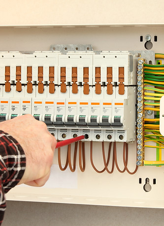 Electrician connecting cables into a fuse box
