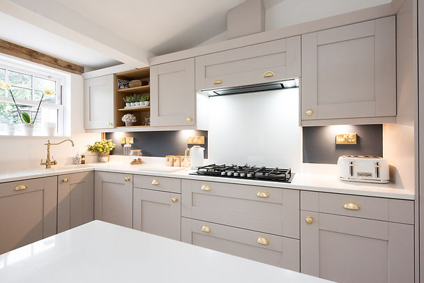 An interior view of a taupe, champagne coloured shaker style fitted kitchen diner with gol
