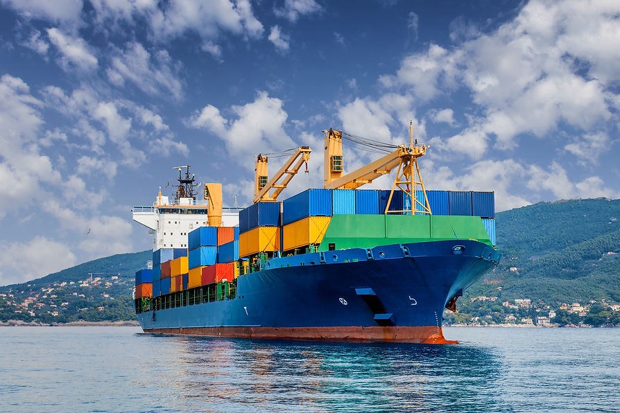 Container cargo ship traversing open sea under cloudy blue sky