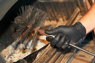 Close-up of a gloved hand holding chimney sweeping brush