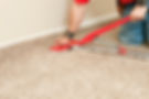 A professional using a carpet stretcher on a new bedroom floor