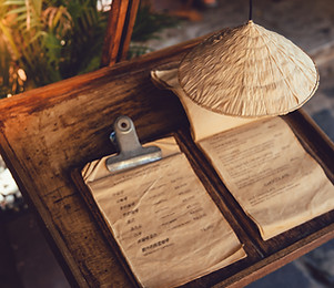 Cone hat decoration above the drinks menu in front of a coffee shop in Vietnam