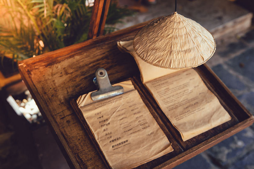 Kegelhutdekoration über der Getränkekarte vor einem Coffeeshop in Vietnam