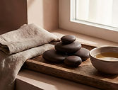 Massage therapy wellness setting with towels, massage stones, and calming amenities