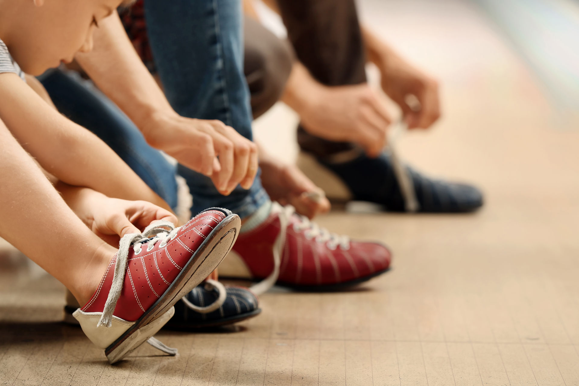 people putting on bowling shoes 