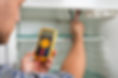 Young Male Technician Checking Fridge With Digital Multimeter