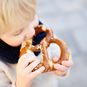 child snacking on a pretzel in between meals