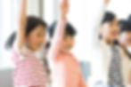 授業で手を挙げる小学生