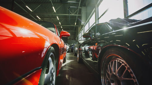 A black and red car parked in a garage, representing a practical and stylish vehicle choice aligned with the 20/4/10 car buying rule—affordable, well-maintained, and within budget.
