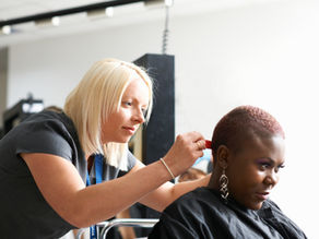 a woman sitting in chair in a hair salon