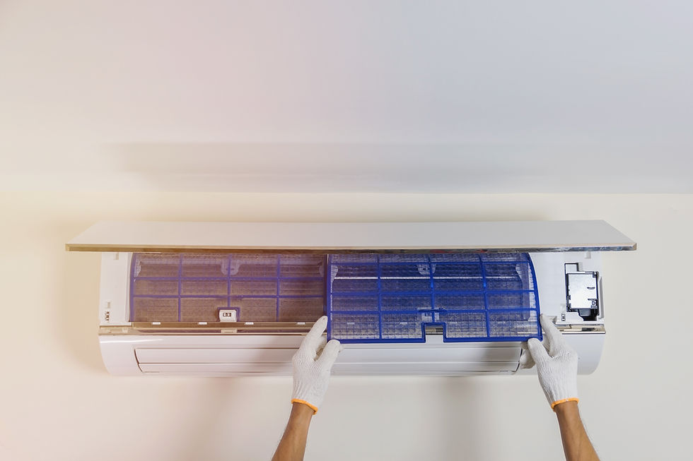 Man's hand is wearing a glove removing the air filter of the air conditioner for cleaning