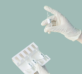 Gloved hands holding vials