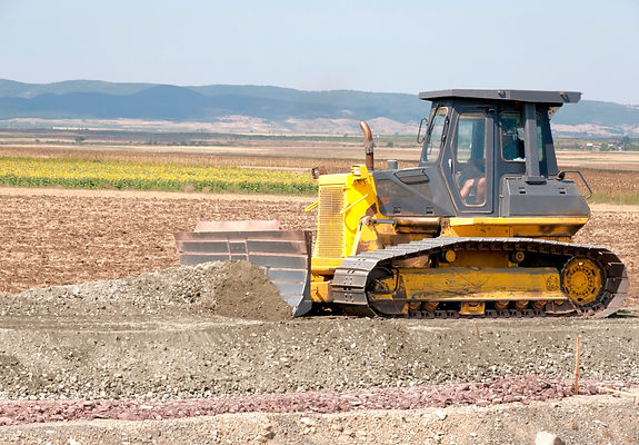 Heavy yellow bulldozer preparing ground on a commercial construction site