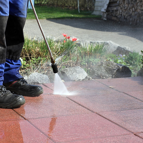 Man cleaning patio using a high-pressure washer