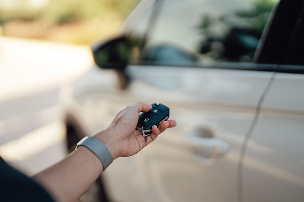 A person's hand holding a car key fob