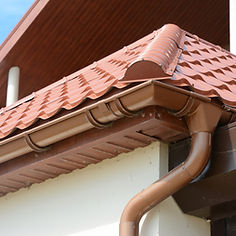 External view of a house featuring clean, well-maintained brown guttering and downpipes