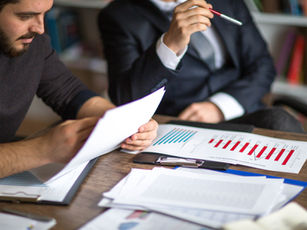 Forensic accountant analysing financial records compared to auditor reviewing financial statements in Australia
