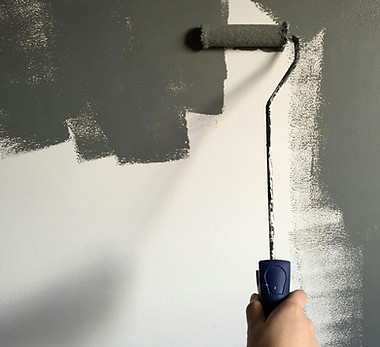Painting wall with grey roller brush