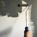 Painting wall with grey roller brush