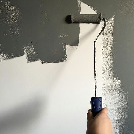 Painting wall with grey roller brush