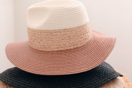 White and pastel straw hats stacked