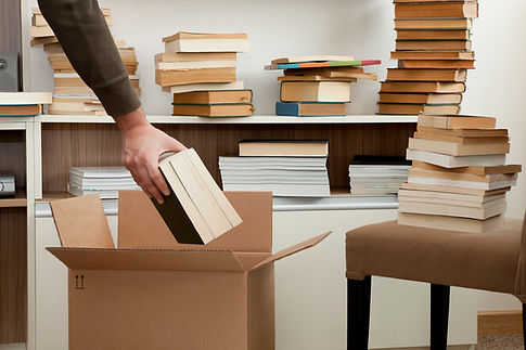 man packing books into a cardboard box during moving