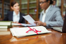 Legal document tied with red tape on table with professional advisers working in background