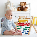 Baby spielt mit Rechenschieber