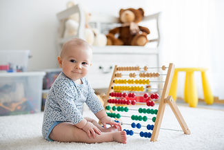 Baby spielt mit Rechenschieber