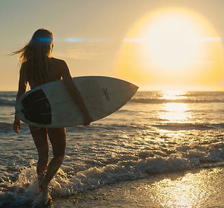 Mujer surfeando al atardecer