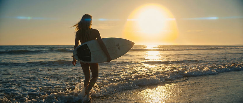 Mujer surfeando al atardecer