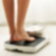 Young fit woman stepping on a bathroom scale. Square shot