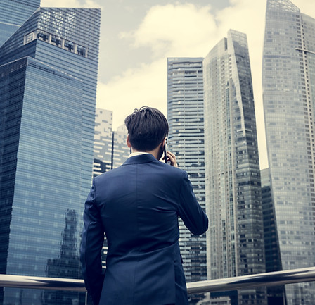 Businessman listening to the phone while looking at the skyscrapers
