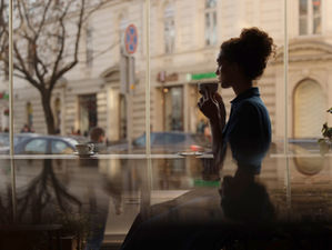 professional woman sitting with coffee, contemplating