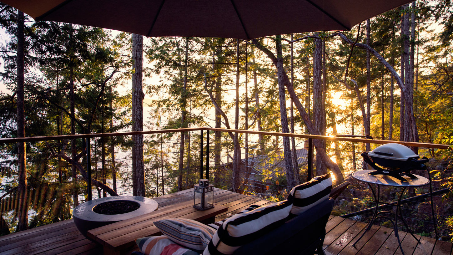Cozy outdoor seating area with forest view at sunset
