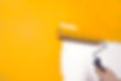 painting a wall orange with a roller