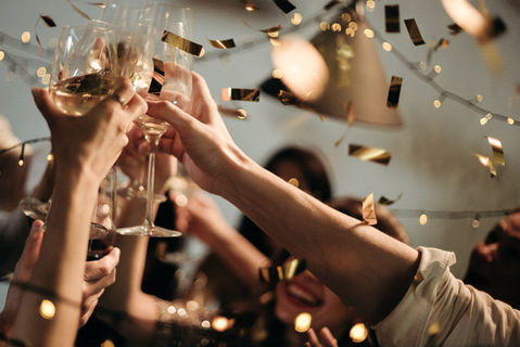 close up detail of champagne toast with confetti
