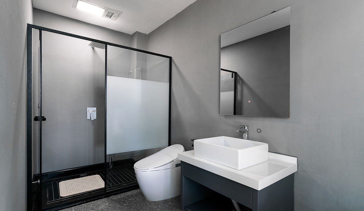 Newly installed grey tiled bathroom