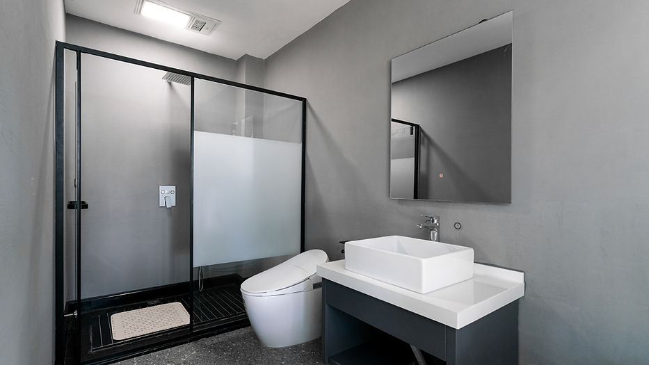 Modern bathroom with grey walls, featuring a glass shower enclosure, a sleek white toilet