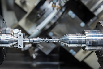Close-up of a precision metal drill bit being machined on a CNC lathe