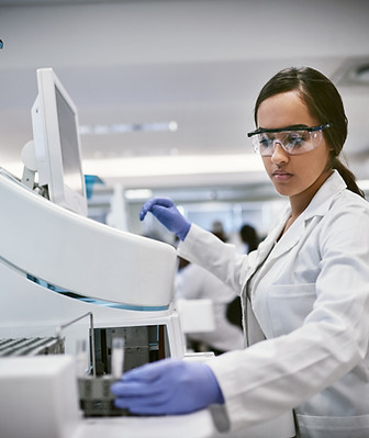 Shot of a young woman using a machine to conduct a medical test in a laboratory