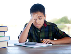 Menino pensando olhando para o caderno