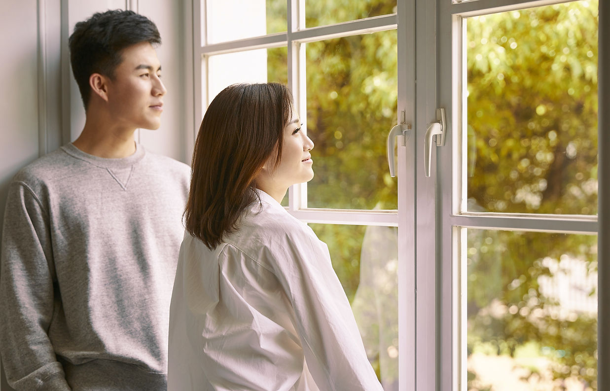 Couple Standing By Window