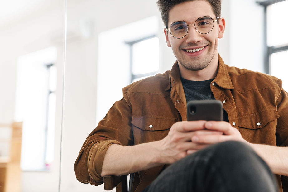 Hombre sonriente enviando mensajes de texto